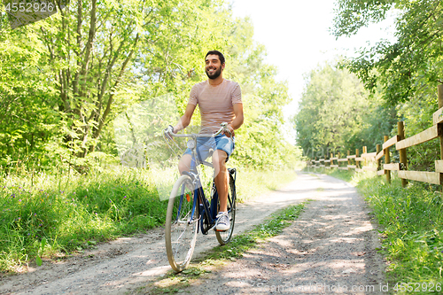 Image of man riding fixie bicycle at summer park