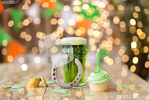 Image of glass of beer, cupcake, horseshoe and gold coins