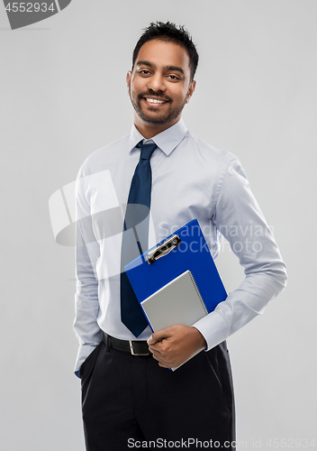 Image of indian businessman with clipboard and notebook