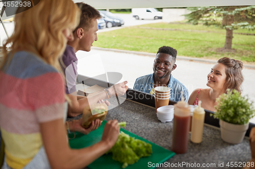 Image of customers couple ordering hamburgers at food truck