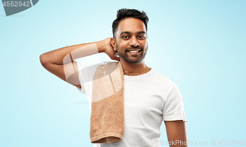 Image of smiling indian man with towel over blue background