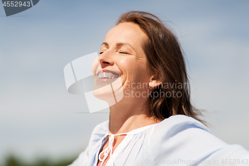 Image of happy smiling woman enjoying sun