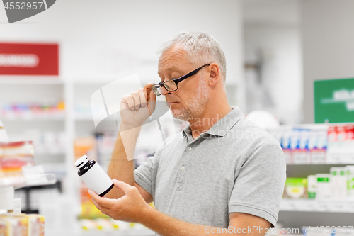 Image of senior male customer with drug at pharmacy