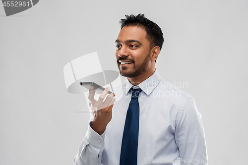 Image of businessman using voice command on smartphone