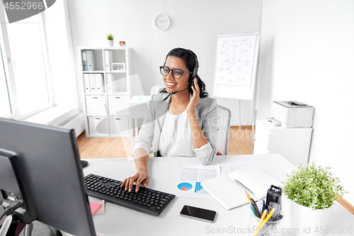 Image of businesswoman with headset and computer at office