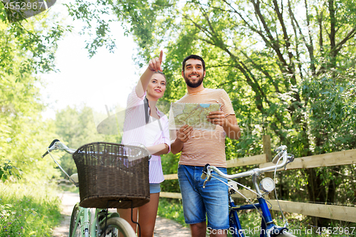 Image of couple with map and bicycles at country in summer