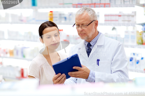 Image of apothecary and customer with tablet pc at pharmacy