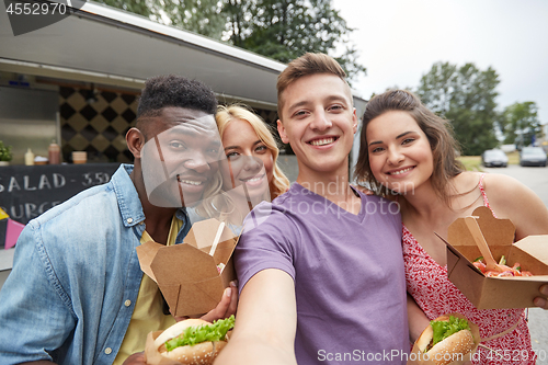 Image of happy friends taking selfie at food truck