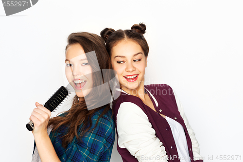 Image of teenage girls singing to hairbrush and having fun