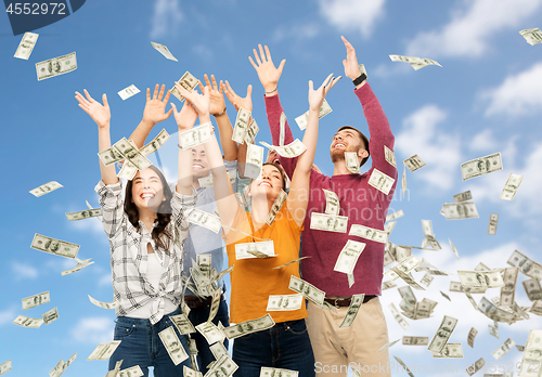 Image of happy friends picking money falling from up above