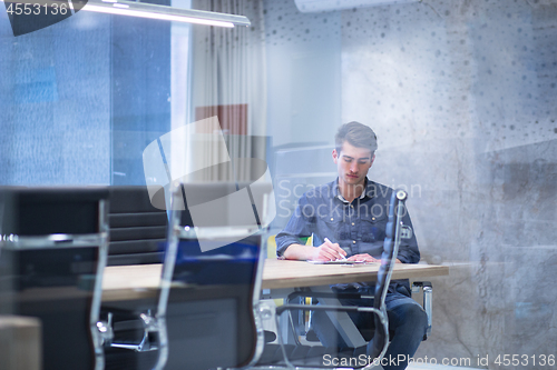 Image of young businessman relaxing at the desk