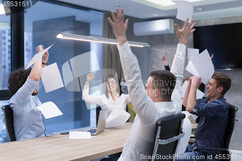Image of startup Group of young business people throwing documents