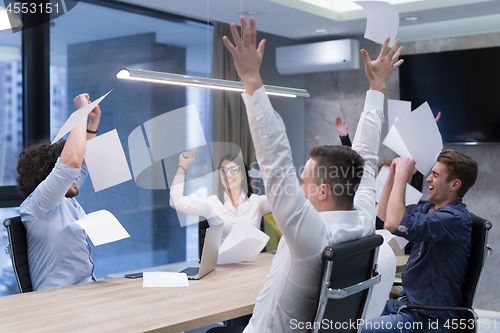 Image of startup Group of young business people throwing documents