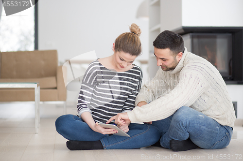 Image of Young Couple using digital tablet on cold winter day