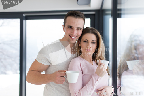 Image of young couple enjoying morning coffee by the window