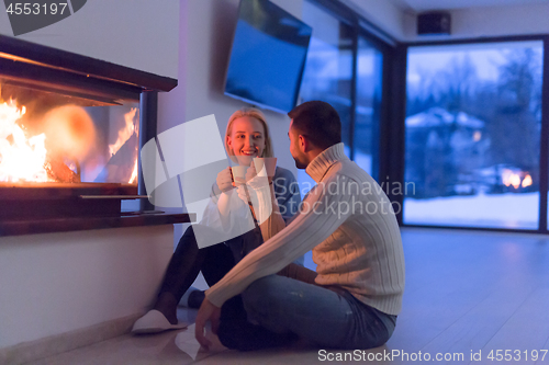 Image of happy couple in front of fireplace