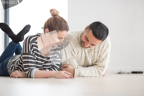 Image of Young Couple using digital tablet on cold winter day