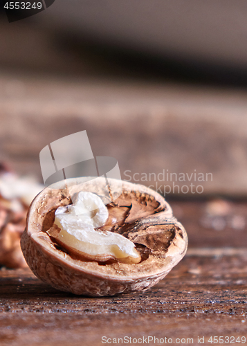 Image of Closeup of a half of walnut on a wooden kitchen table with copy space. Vegetarian product