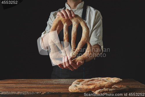 Image of Baker\'s hands hold fougas bread