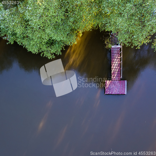 Image of View from above on a wooden bridge, lake and green trees