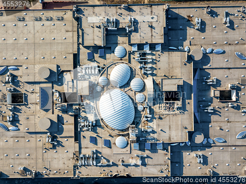 Image of Aerial view from the drones, top view of the roof of the shopping center with ventilation outlets, antennas and roof equipment.
