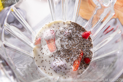 Image of Pink smoothie in a blender with strawberries and chia seeds, view from above