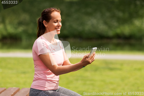 Image of woman with smartphone at summer park