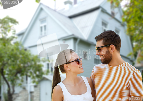 Image of happy couple in sunglasses in summer over house