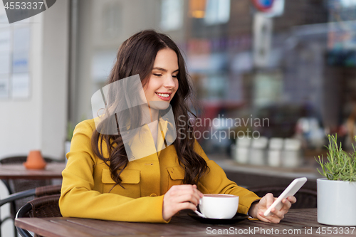 Image of teenage girl with smartphone and hot drink at cafe