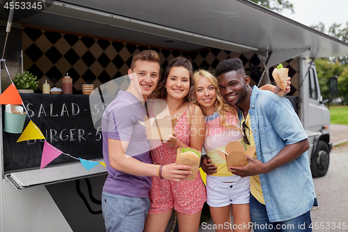 Image of happy friends with wok and burger at food truck