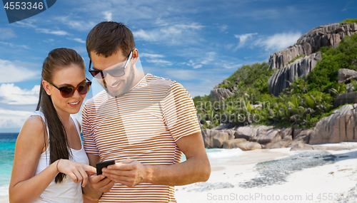 Image of happy couple with smartphone on seychelles island