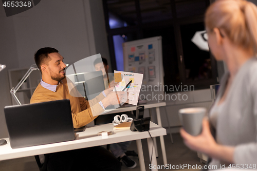 Image of business team with papers working late at office