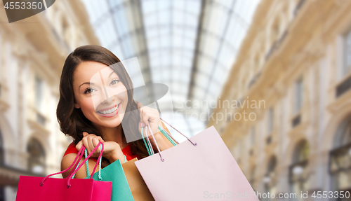 Image of woman with shopping bags over mall background