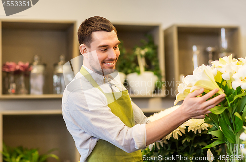 Image of florist or seller with white lilies at flower shop