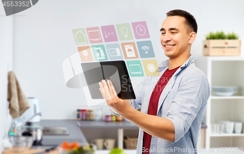 Image of happy young man with tablet computer in kitchen