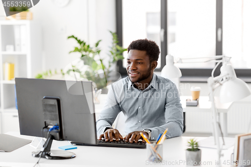 Image of african businessman with computer at office