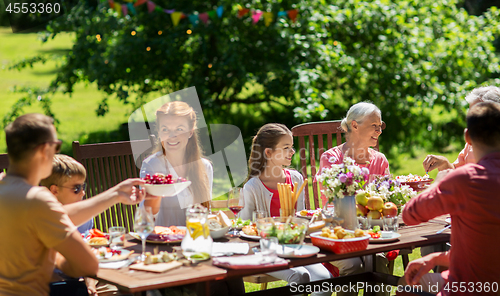 Image of happy family having dinner or summer garden party