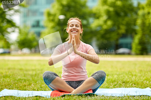 Image of happy woman meditating in summer park