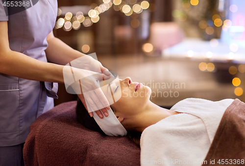 Image of woman having face and head massage at spa