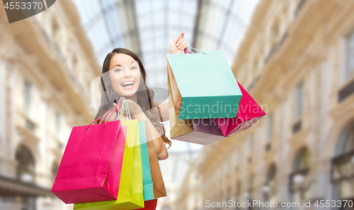 Image of woman with shopping bags over mall background