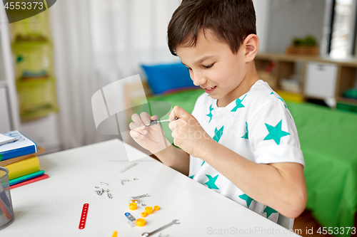 Image of little boy playing with building kit at home