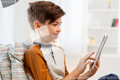Image of smiling boy with tablet pc computer at home