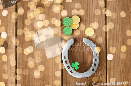 Image of horseshoe with shamrock on wooden background