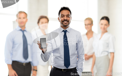 Image of indian businessman with smartphone at office