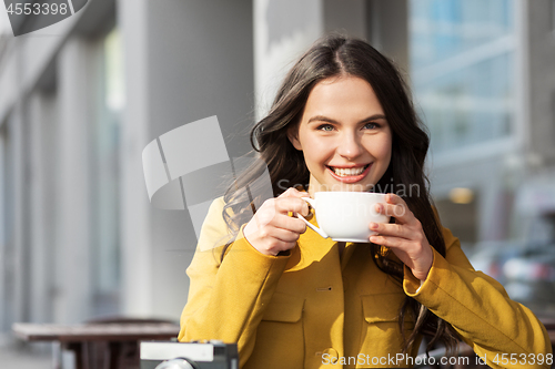 Image of teenage girl drinking hot chocolate at city cafe