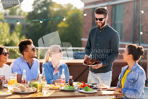 Image of friends at bbq party on rooftop in summer
