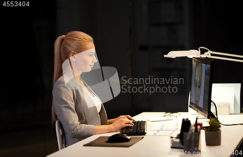Image of designer with computer working at nigh office