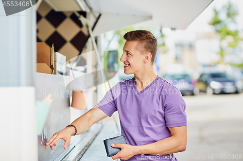 Image of male customer with wallet at food truck