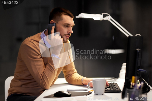 Image of businessman calling on sartphone at night office