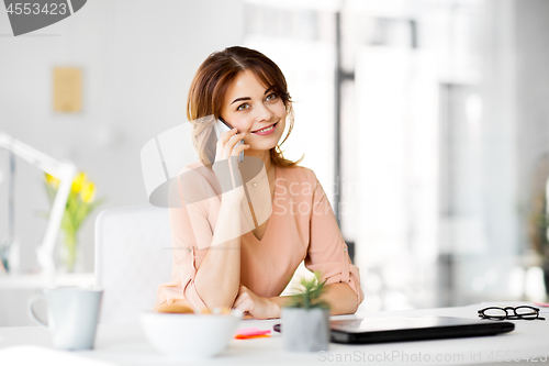 Image of businesswoman calling on smartphone at office